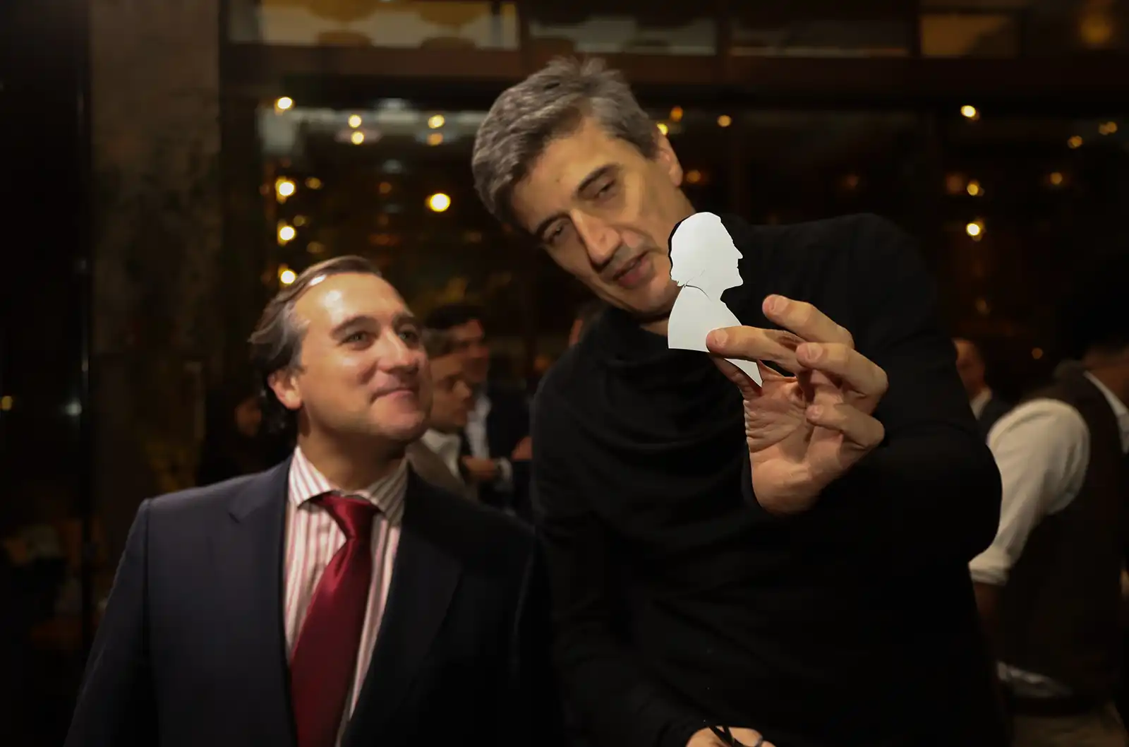 Igor Kucinic mostra a un ospite il ritratto silhouette appena completato
