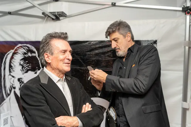 Igor Kucinic, silhouettista, ritaglia con le forbici il ritratto di profilo di un ospite sotto il gazebo della festa dei 100 anni